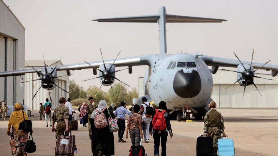 British nationals walk to board an RAF aircraft during the evacuation to Cyprus, at Wadi Seidna airport, Sudan