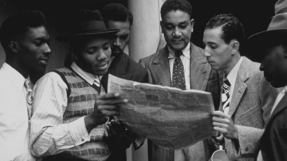 Jamaicans reading a newspaper on board the "Empire Windrush"