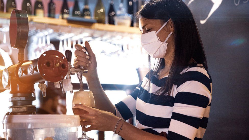 Woman pouring pint in pub