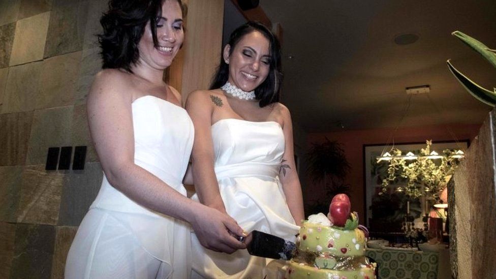 Alexandra Quiros (L) and Dunia Araya (R) cut a cake during their wedding in Heredia, Costa Rica, on May 26, 2020.