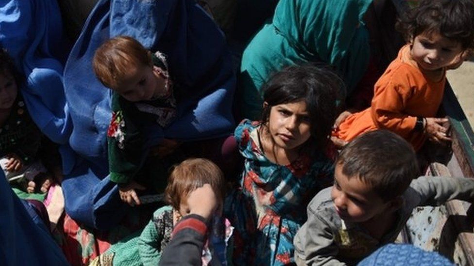 Afghan women and children sit in a truck