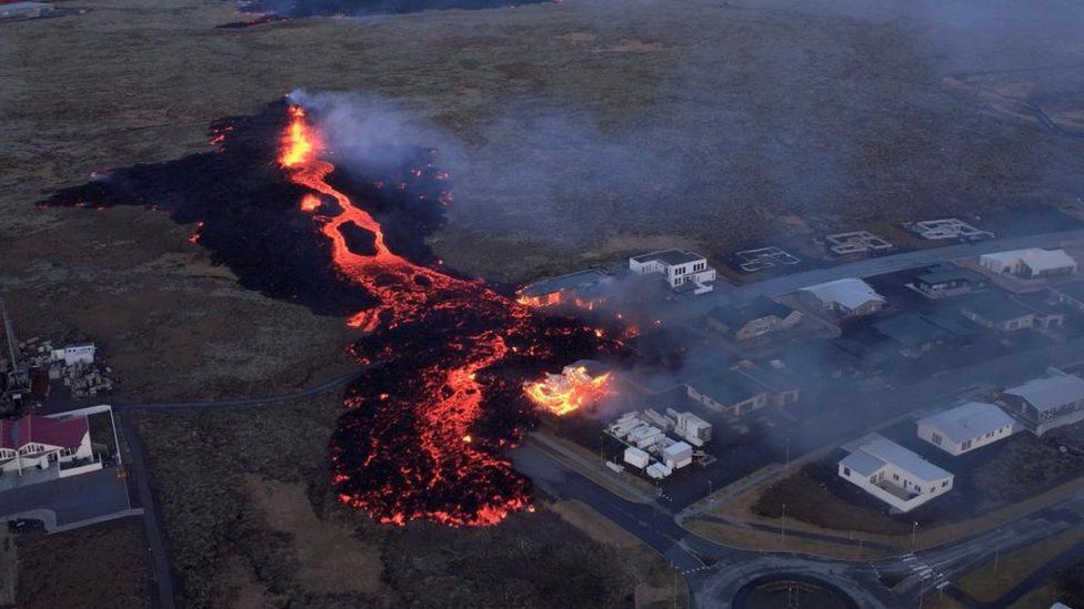 Lava flows from a volcano as houses burn in Grindavik, Iceland, January 14, 2024