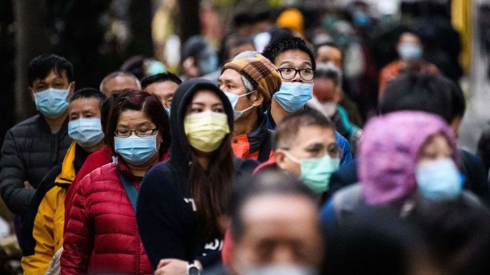 People line up in Hong Kong to to purchase face masks from a makeshift stall