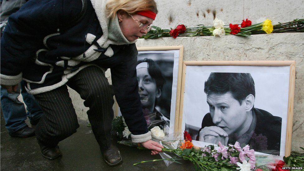 A woman places flowers near portraits of slain Russian lawyer Stanislav Markelov, 34, (right) and 25-year-old reporter Anastasiya Baburova at the spot of their murder, in Moscow on February 27, 2009, forty days after the incident