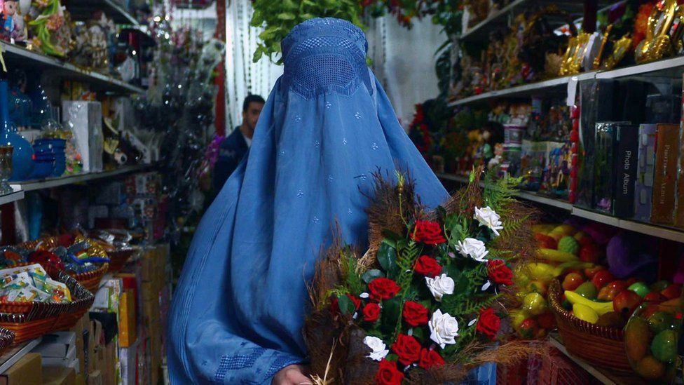 Woman in burqa holding roses