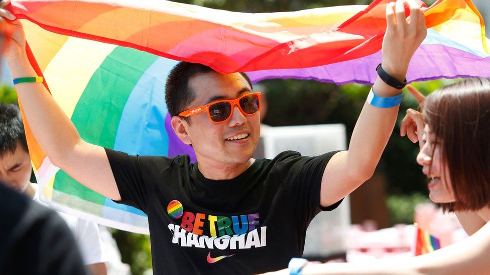 A man holds a rainbow flag after taking part in the Pride Run in Shanghai