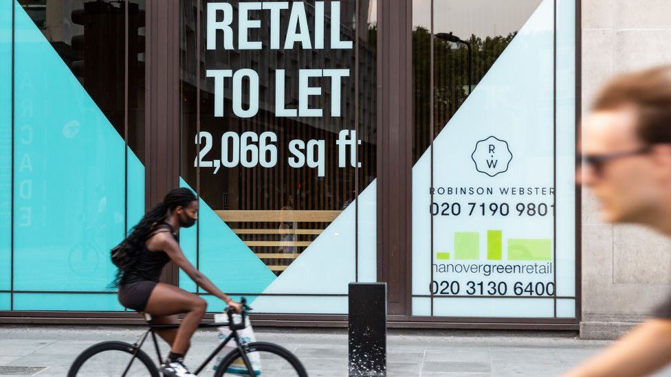 People cycling past a ''to let'' sign