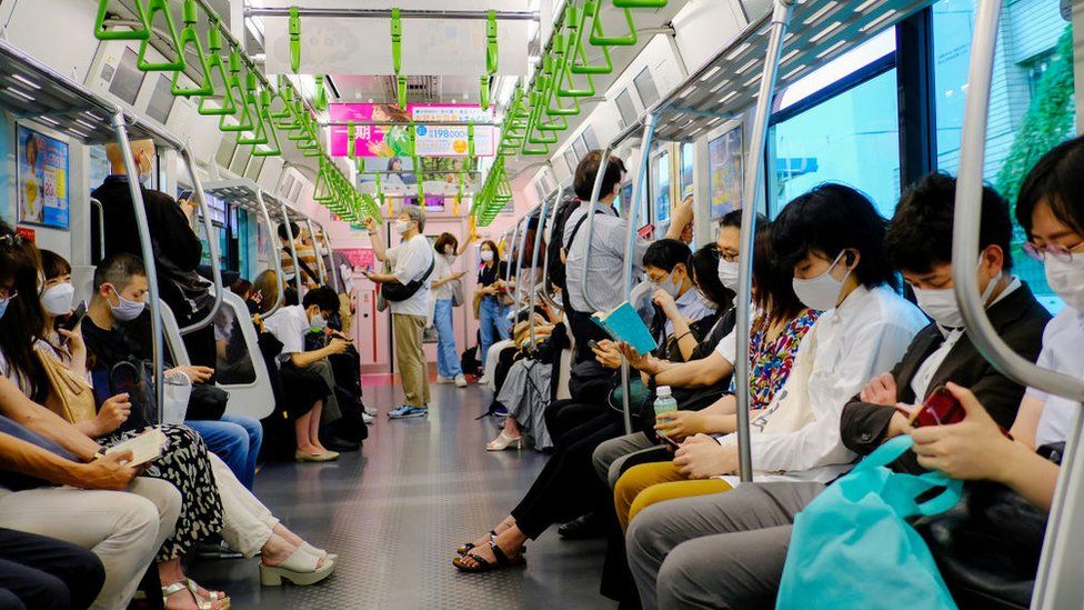 Пассажиры в масках в качестве превентивной меры против распространения covid-19 замечены в поезде линии Яманотэ в Токио