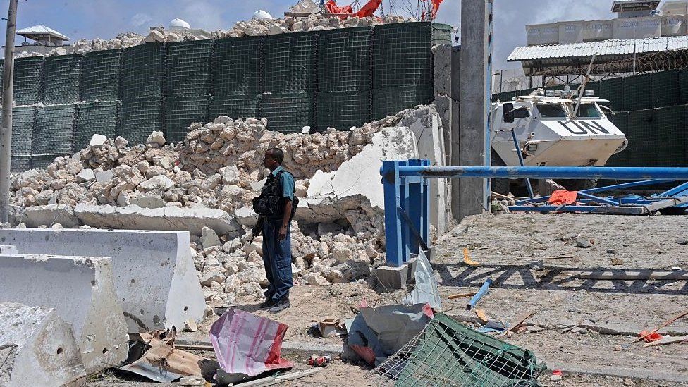 Man standing next to rubble