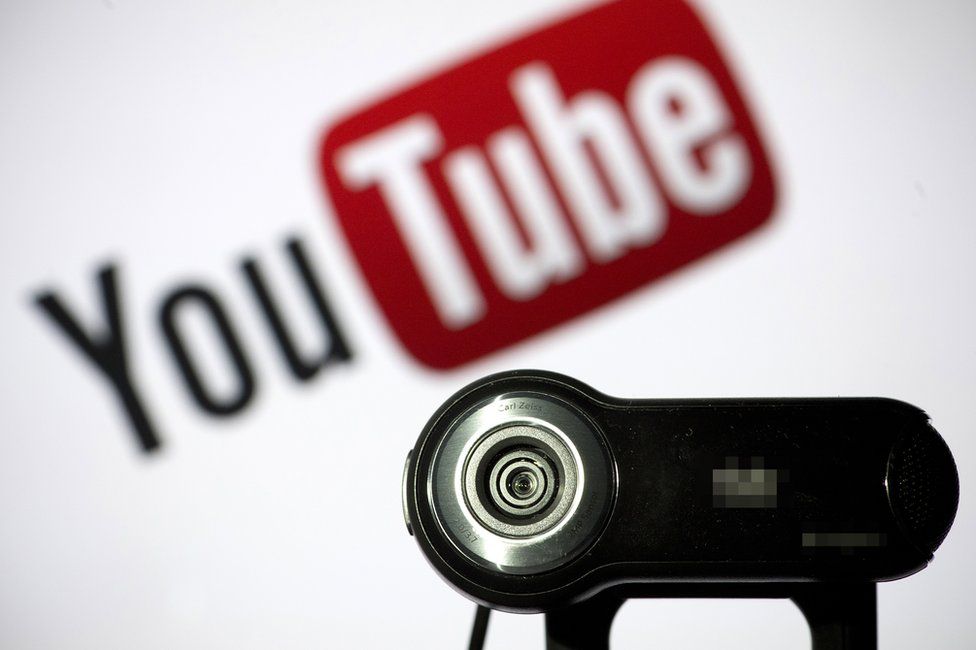 A webcam is positioned in front of YouTube's logo on June 28, 2013