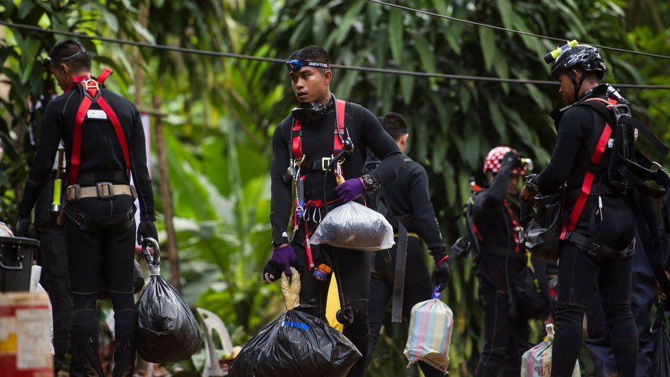 Thai divers carry supplies as rescue operations continue for 12 boys and their coach trapped at Tham Luang cave at Khun Nam Nang Non Forest Park in the Mae Sai district of Chiang Rai province on July 5, 2018.
