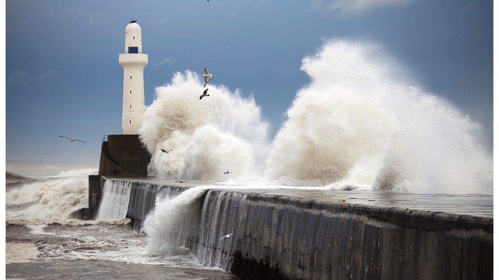 waves crashing around lighthouse