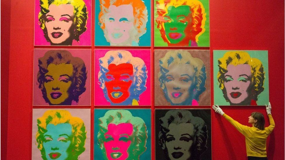 A member of the British Museum staff makes a final adjustments to a selection of ten colour Andy Warhol screen prints featuring Marilyn Monroe in February 10, 2017