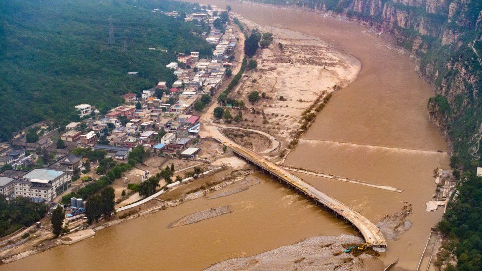 Aerial view of excavators operating to repair the collapsed roads in flood-hit areas in Fangshan District on August 4, 2023 in Beijing, China.