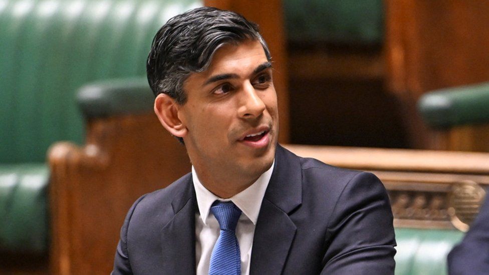 Sunak looking away from camera while wearing a suit and blue tie as he speaks in Parliament on 23 January