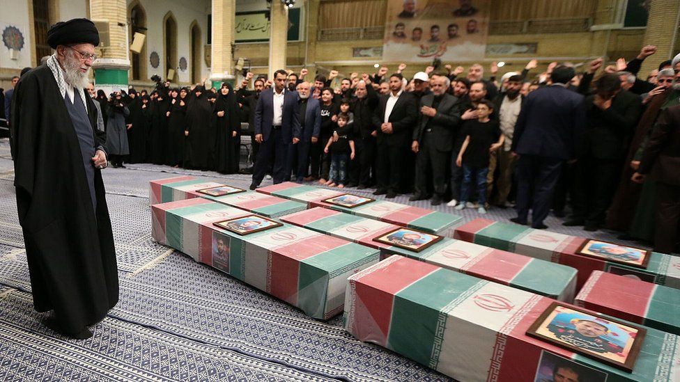 Iranian Supreme Leader Ayatollah Ali Khamenei praying over coffins of revolutionary guards