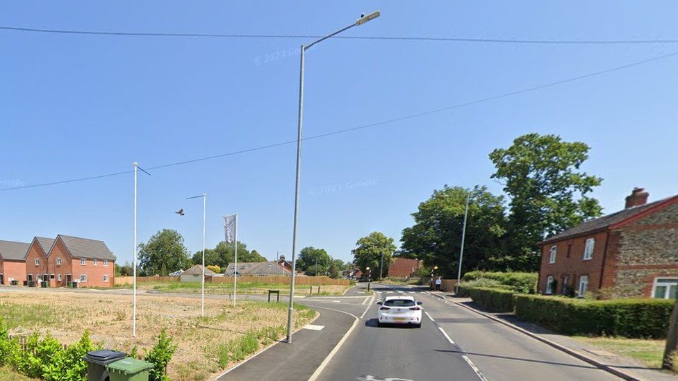 Undeveloped land where the pub used to be, and a road into a new housing development
