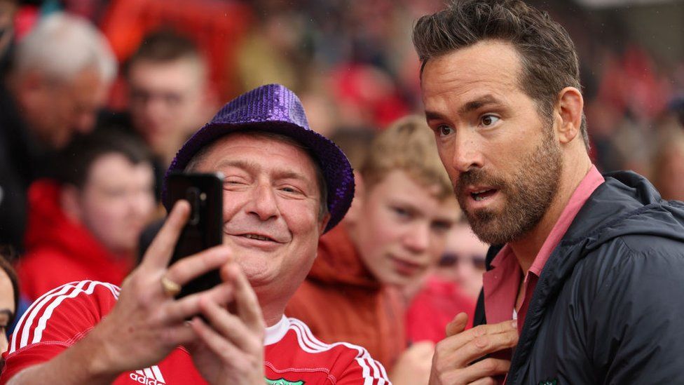 Wrexham co-owner Ryan Reynolds poses for pictures with fans before kick-off