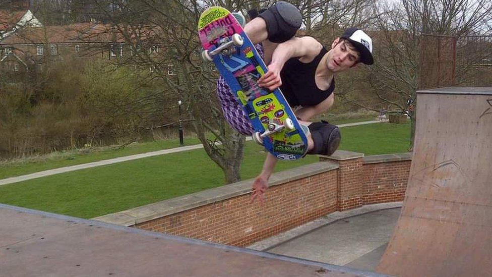 Skateboarder using half pipe skate ramp