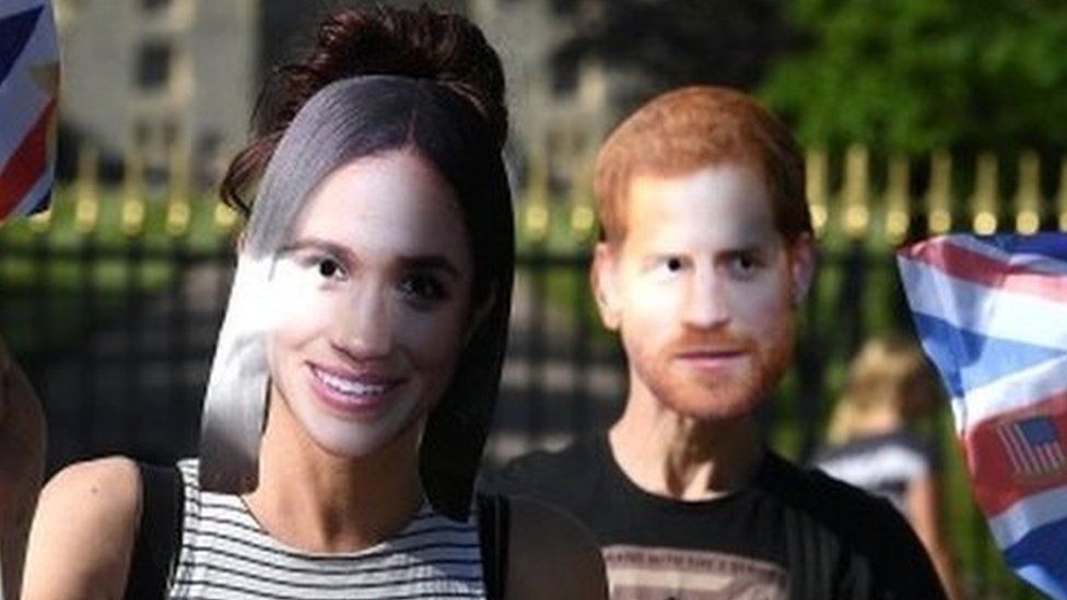 People pose for a picture in Prince Harry and Meghan Markle masks