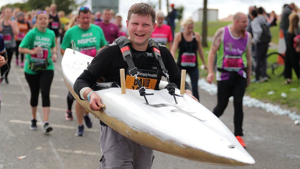 A runner carries a canoe