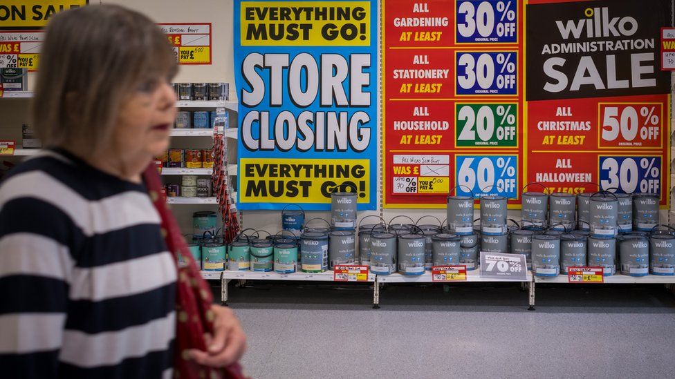 A shopper at Wilko with lots of closing down signs