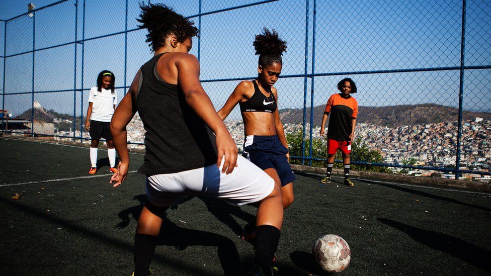 Competitive training on the field, as one girl attempts to evade a tackle from her training partner