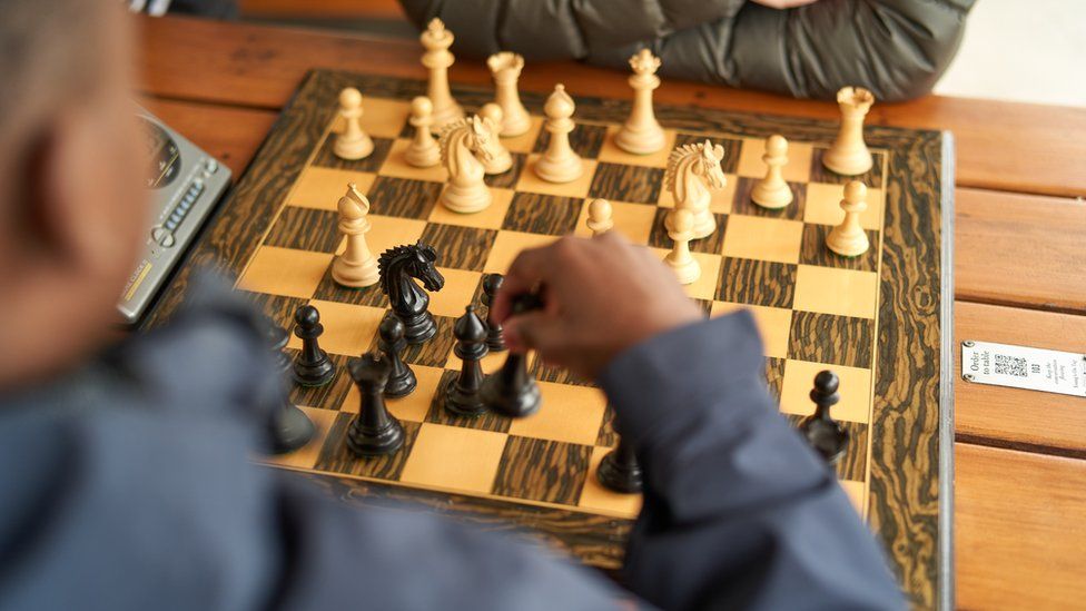 A young boy makes his play on the chess board at The Old Royal Naval College in Greenwich