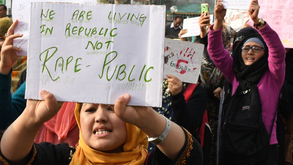 Protesters hold signs during a protest against the rape and murder of an eight-year-old child in Kashmir.