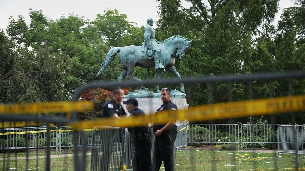 Police stand watch near the statue of Confederate General Robert E Lee in the centre of Emancipation Park the day after the Unite the Right rally in Charlottesville, Virginia.
