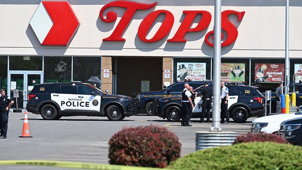Police cars and tape outside a Tops supermarket in Buffalo, New York where the shooting took place