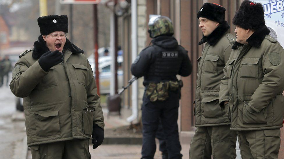Russian Cossacks and police officer stand guard during hearing of former Ukrainian army pilot Nadiya Savchenko near in the southern border town of Donetsk in Rostov region, Russia. 22 March 2016