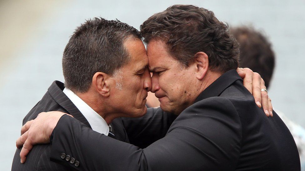 Dallas Seymour (left) and Michael Jones (right) perform the Maori nose-rubbing greeting, the hongi, after the memorial service
