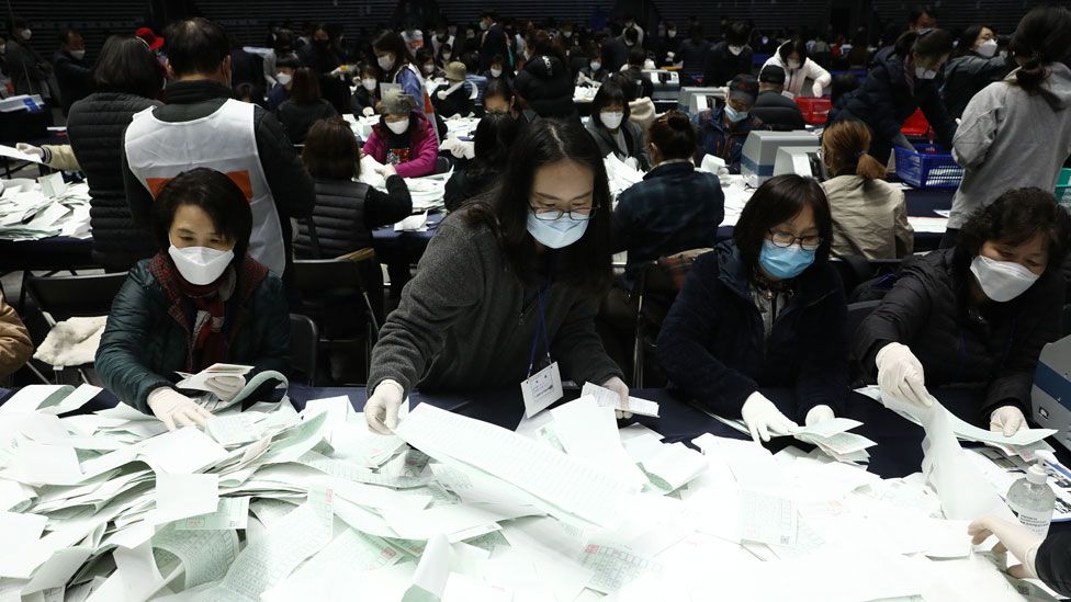 Officials from the South Korean Central Election Management Committee and election observers count votes