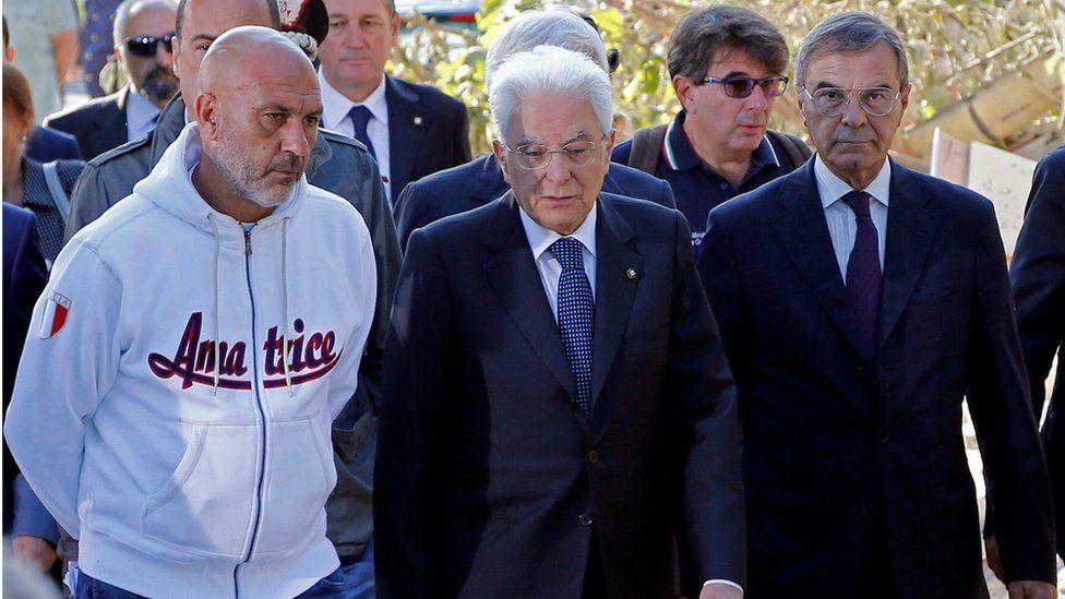 Italian President Sergio Mattarella (centre) is seen with Amatrice mayor Sergio Pirozzi (left) during his visit to Amatrice 27 August 2016