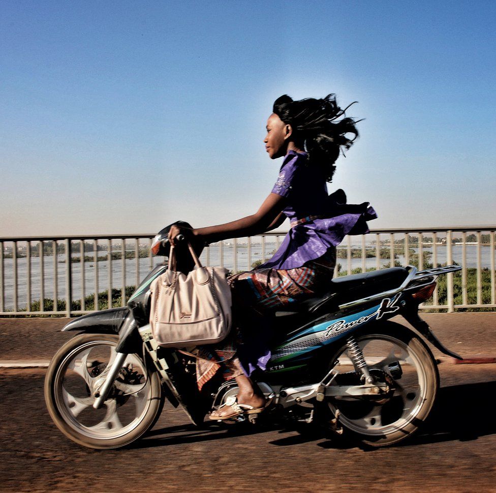 A woman riding a motorbike