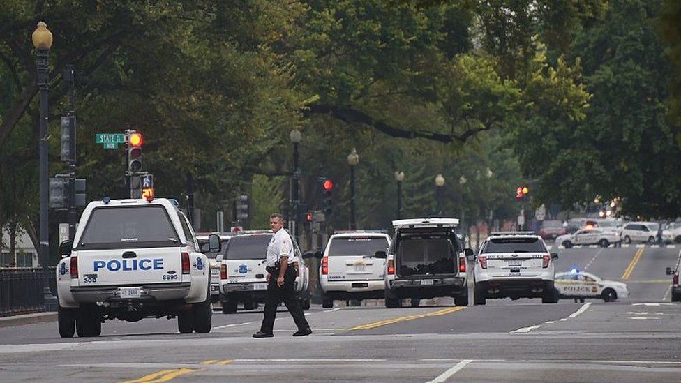 A member of the Secret Service walks across 17th Avenue and Constitution in Washington DC after a security incident in on 2 October 2014