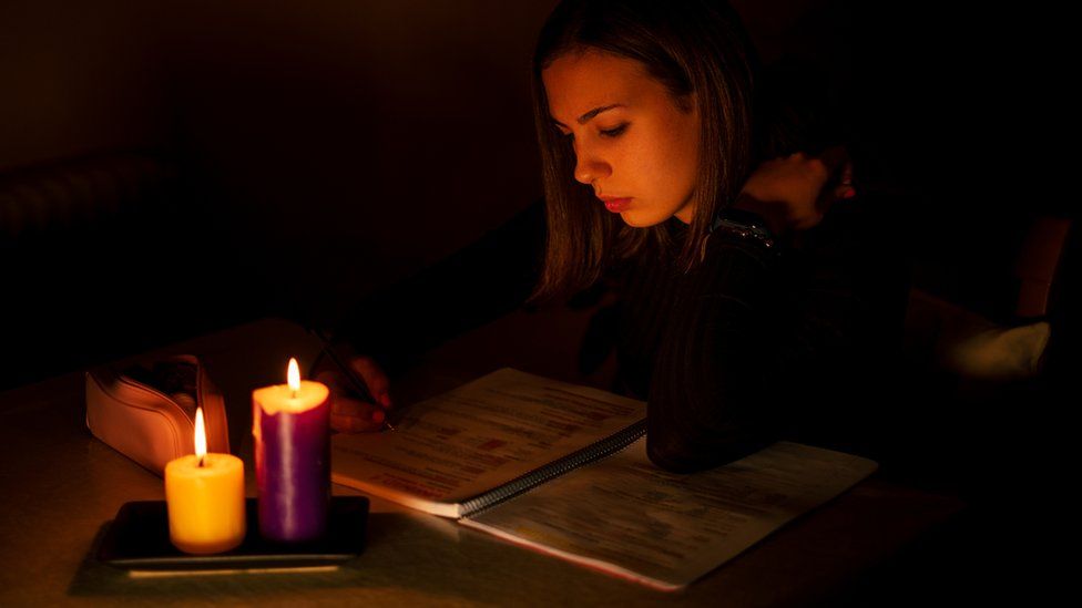 teenager studying by canclelight