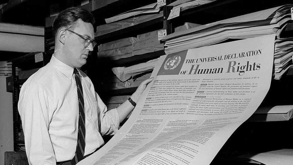 A man looks at one of the first documents published by the United Nations, The Universal Declaration of Human Rights