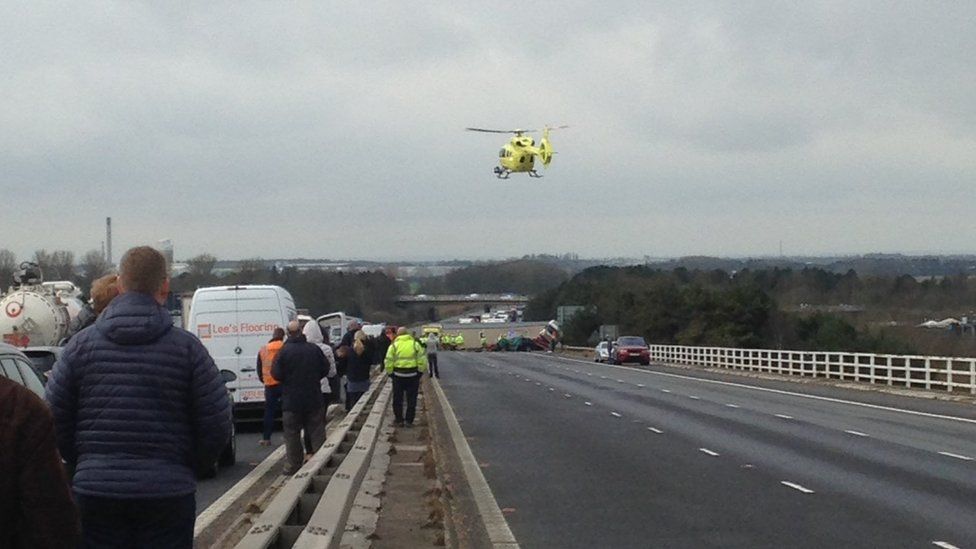 Air ambulance hovering in the sky above a lorry and car crash