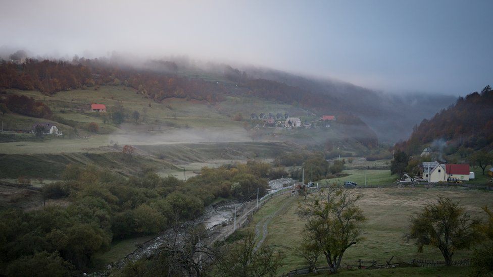 Misty valley landscape with a few houses