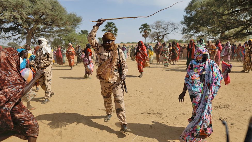 A stick-wielding soldier amidst Sudanese refugees in Koufroun, Chad - Sunday 7 May 2023