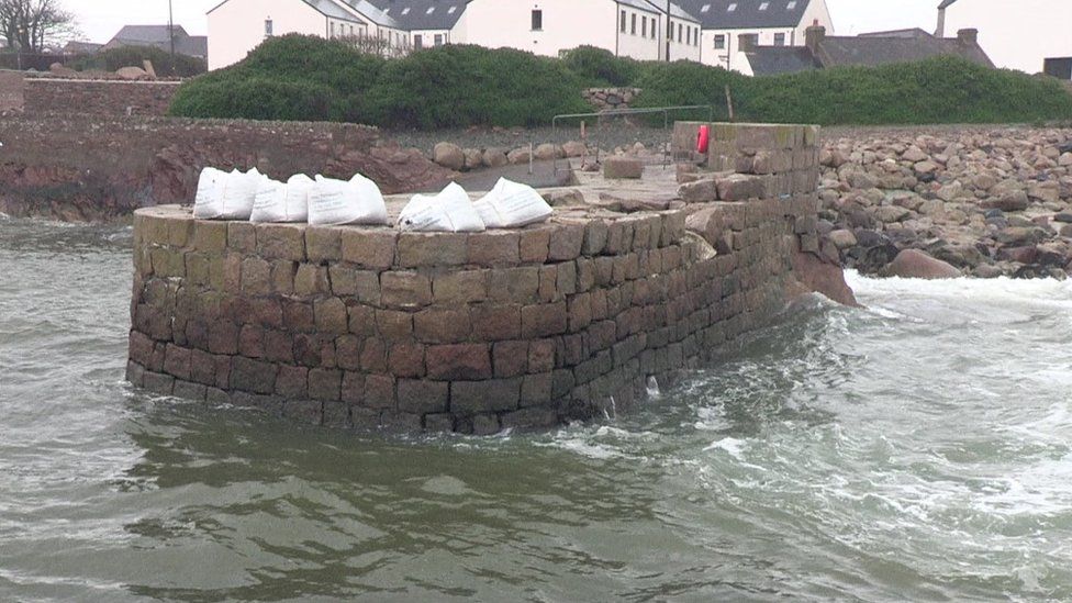 Large bags of granite to be used in the repair work sit on the north pier at Annalong Harbour