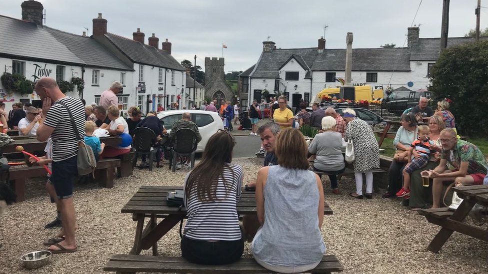 People gathered on pub benches