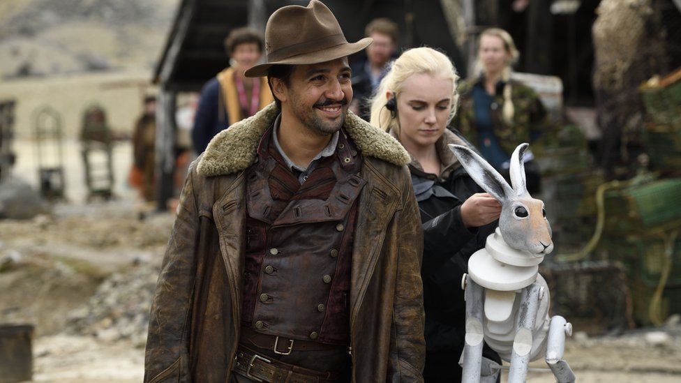 Lin-Manuel Miranda on set with a model of his hare "daemon"