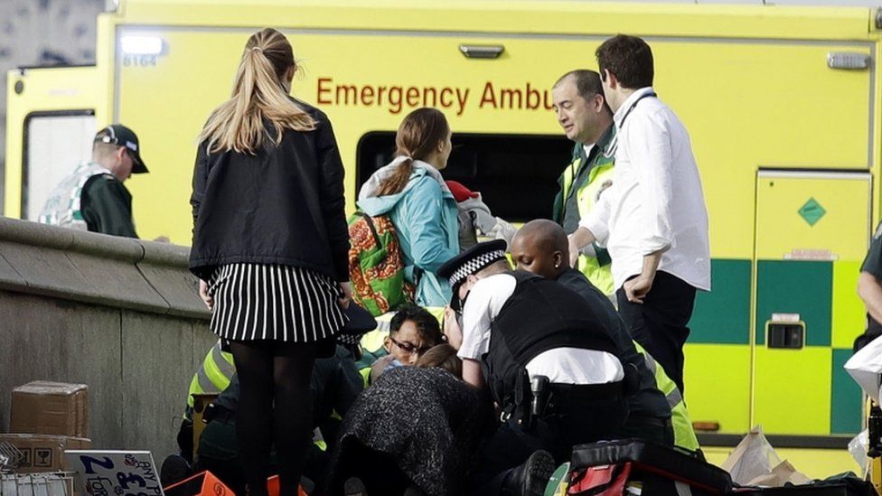 Emergency services staff provide medical attention close to the Houses of Parliament in London