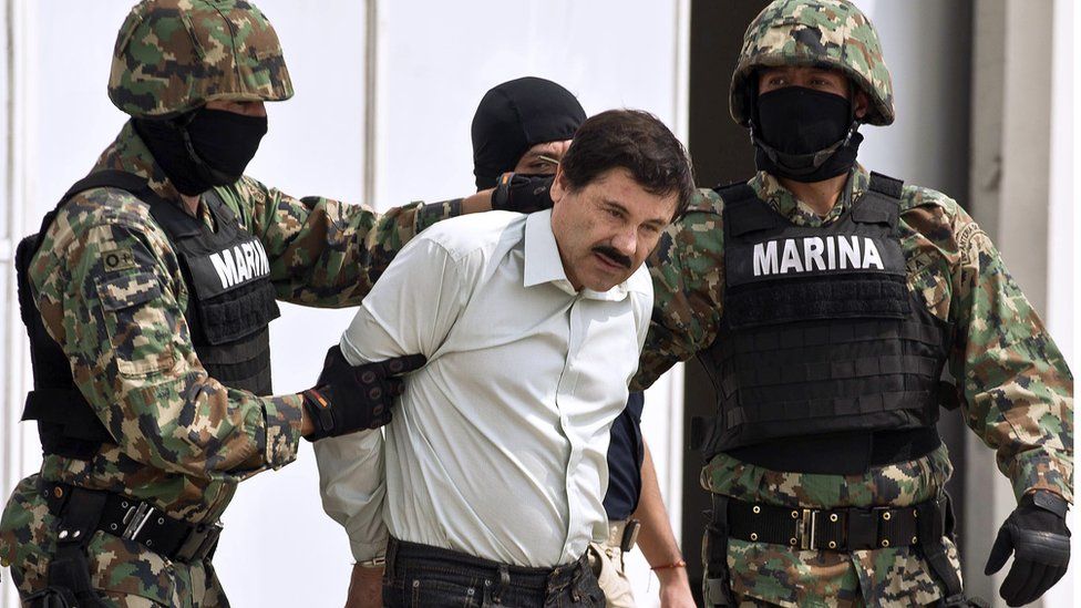 Joaquin El Chapo Guzman is escorted by marines as he is presented to the press on 22 February 2014