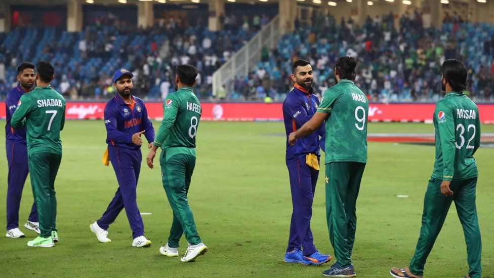 Игроки из Пакистана и Индии обмениваются рукопожатием после матча чемпионата мира ICC среди мужчин T20 между Индией и Пакистаном на международном стадионе Дубая 24 октября 2021 года в Дубае, Объединенные Арабские Эмираты.