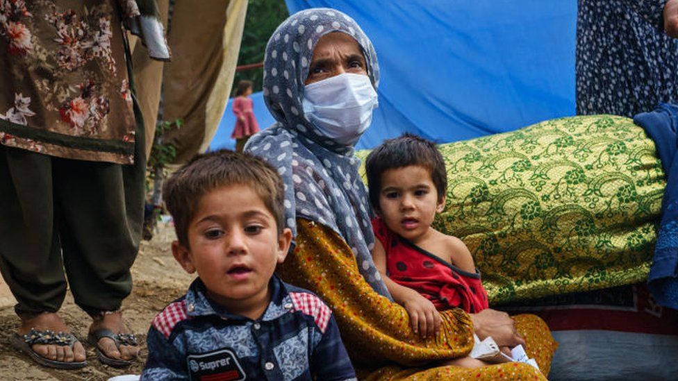 An Afghan woman and her family in a camp in Kabul