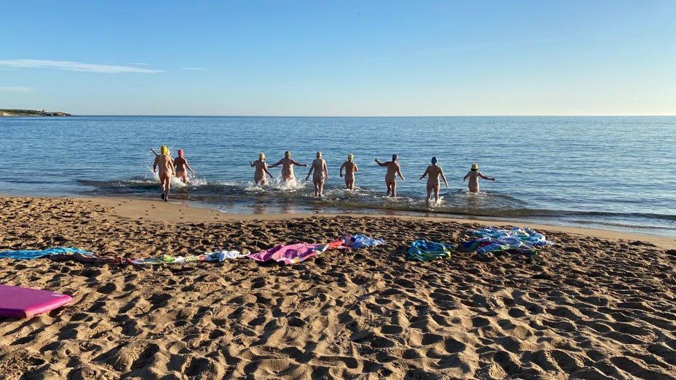 A group of Women's Institute members running into the sea